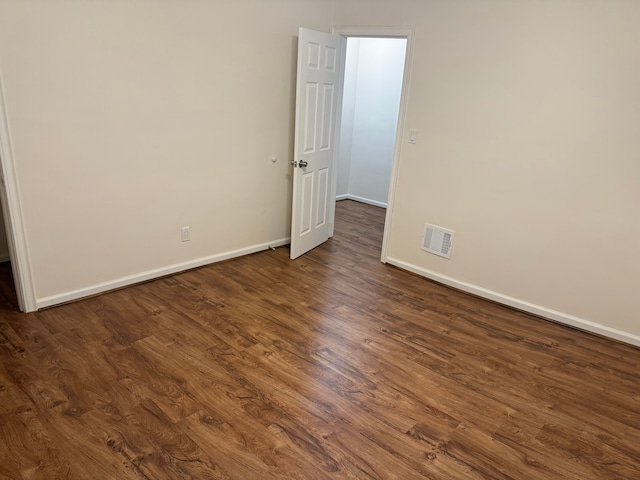 empty room with dark hardwood / wood-style flooring