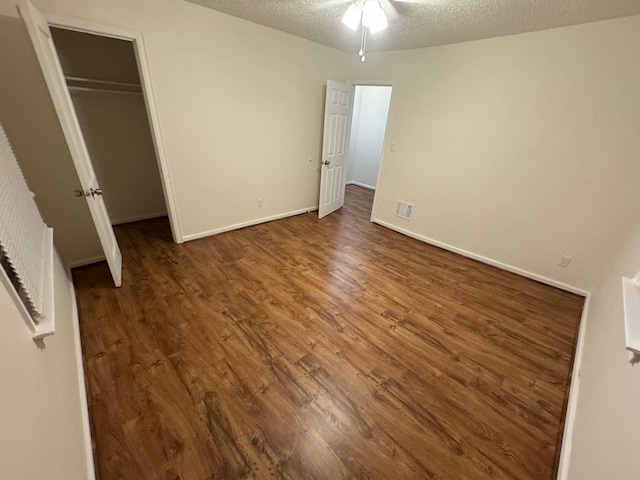 unfurnished bedroom with a closet, dark hardwood / wood-style floors, and a textured ceiling