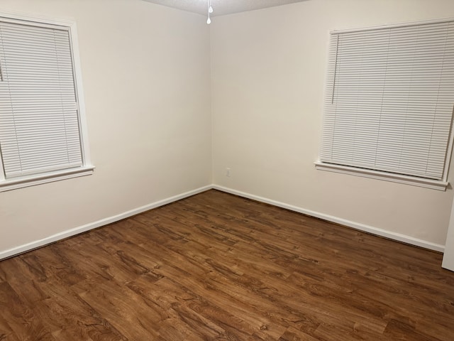 spare room with dark wood-type flooring and a textured ceiling