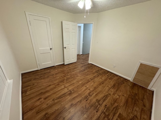 unfurnished bedroom with dark hardwood / wood-style flooring and a textured ceiling