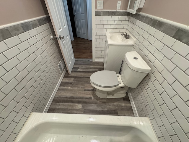 bathroom featuring hardwood / wood-style flooring, vanity, tile walls, and toilet