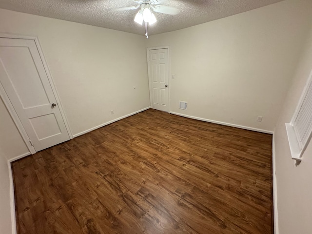 unfurnished bedroom with ceiling fan, dark wood-type flooring, and a textured ceiling