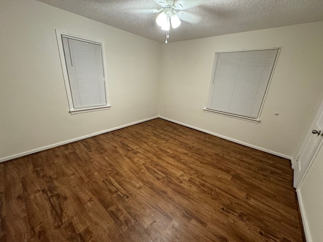 spare room featuring ceiling fan, dark wood-type flooring, and a textured ceiling