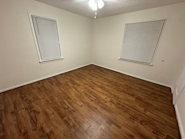 spare room with ceiling fan, dark hardwood / wood-style floors, and a textured ceiling