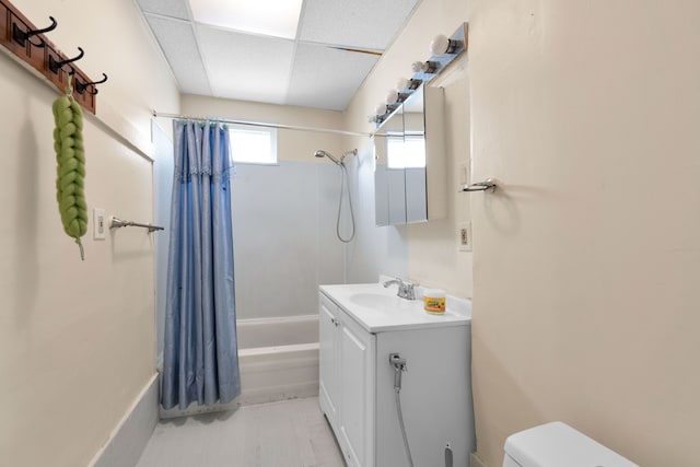 full bathroom with shower / bath combo, vanity, toilet, and a paneled ceiling