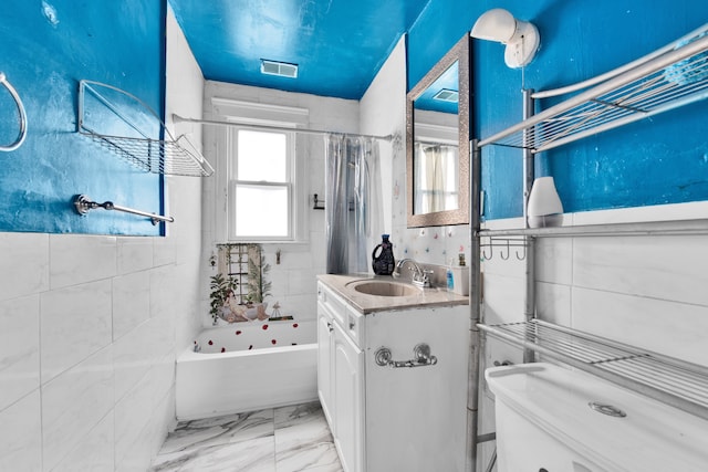 bathroom featuring vanity, tile walls, and shower / bath combo with shower curtain