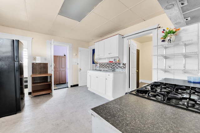 kitchen with white cabinets, sink, tasteful backsplash, and black appliances