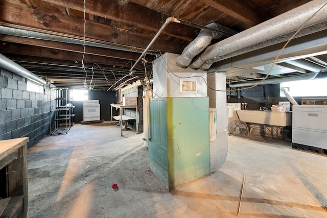 basement with washer / dryer, sink, a wealth of natural light, and heating unit