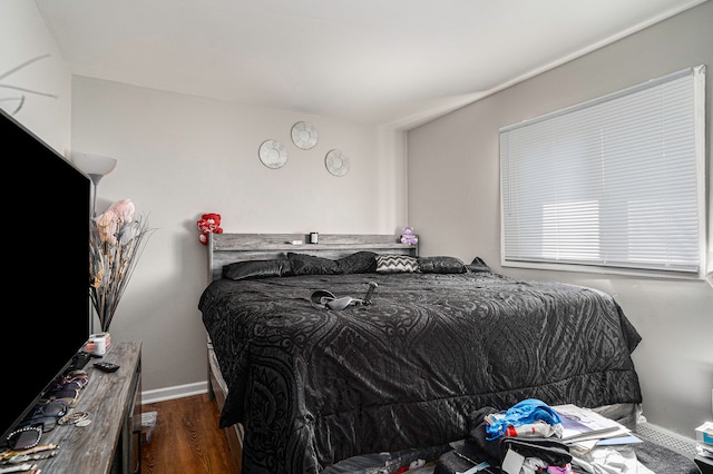 bedroom with dark hardwood / wood-style flooring