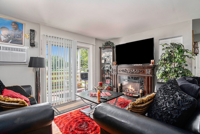 living room featuring a wall unit AC and a fireplace