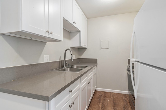 kitchen with stainless steel oven, dark wood-type flooring, sink, white refrigerator, and white cabinetry