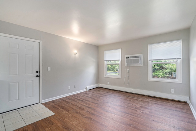 interior space featuring an AC wall unit, wood-type flooring, and baseboard heating