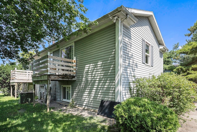 view of property exterior with a lawn and a balcony