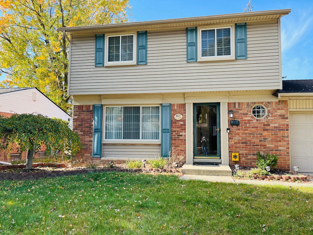 view of front facade featuring a front yard and a garage