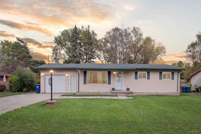 ranch-style home featuring a garage and a yard