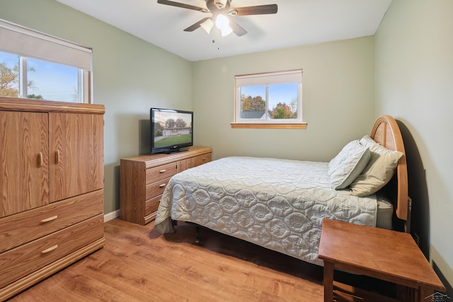 bedroom featuring light hardwood / wood-style floors, multiple windows, and ceiling fan