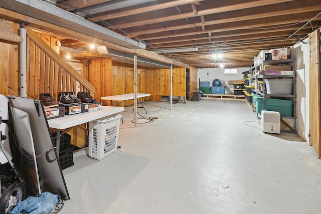 basement featuring wooden walls