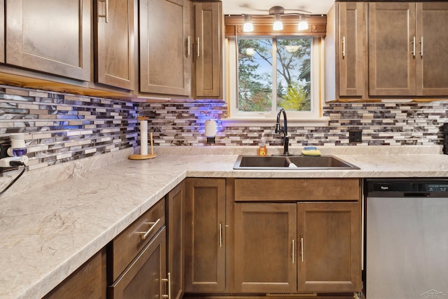 kitchen featuring backsplash, dishwasher, and sink