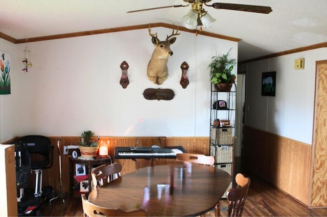 dining area featuring dark hardwood / wood-style flooring, crown molding, and wooden walls