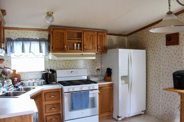 kitchen with white appliances, sink, crown molding, hanging light fixtures, and a textured ceiling