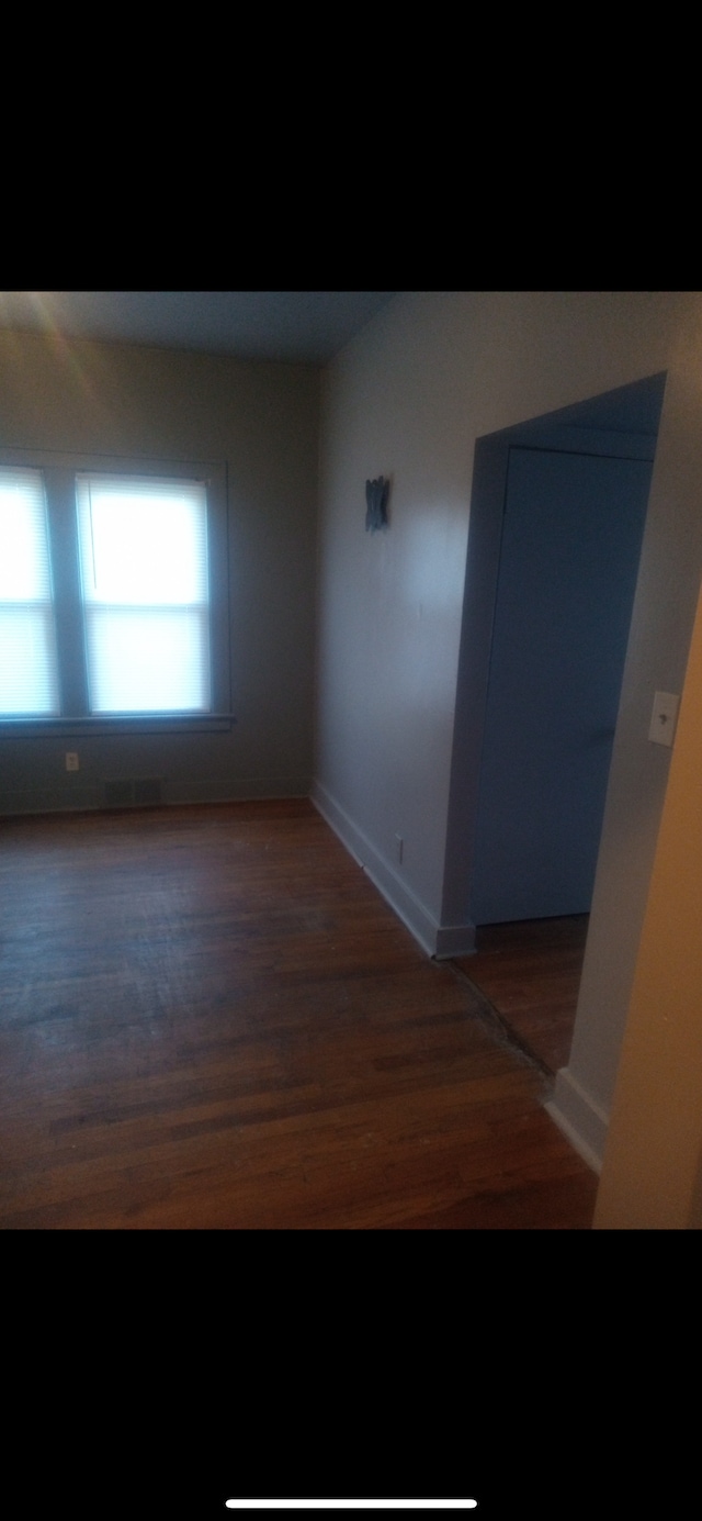 unfurnished room featuring dark wood-type flooring