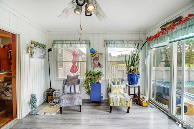 unfurnished sunroom featuring ceiling fan and a healthy amount of sunlight