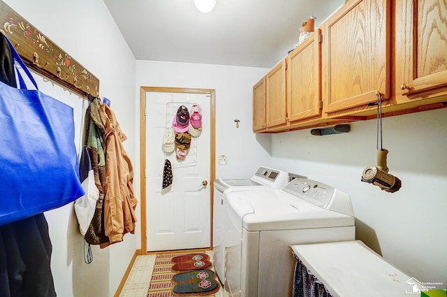 washroom with cabinets and washer and dryer