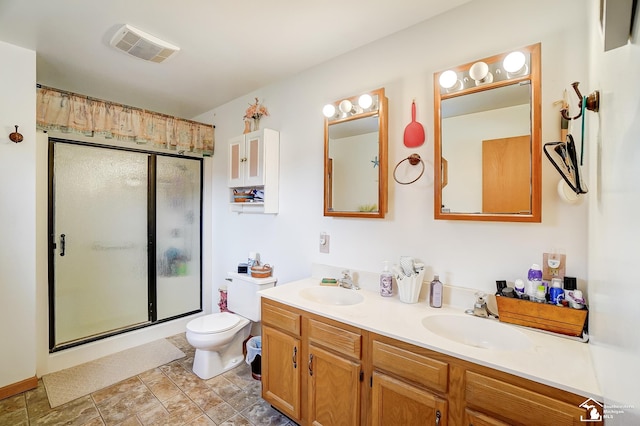 bathroom with vanity, toilet, and a shower with shower door