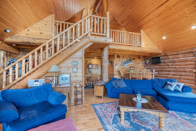 living room with hardwood / wood-style floors, wooden ceiling, rustic walls, and high vaulted ceiling