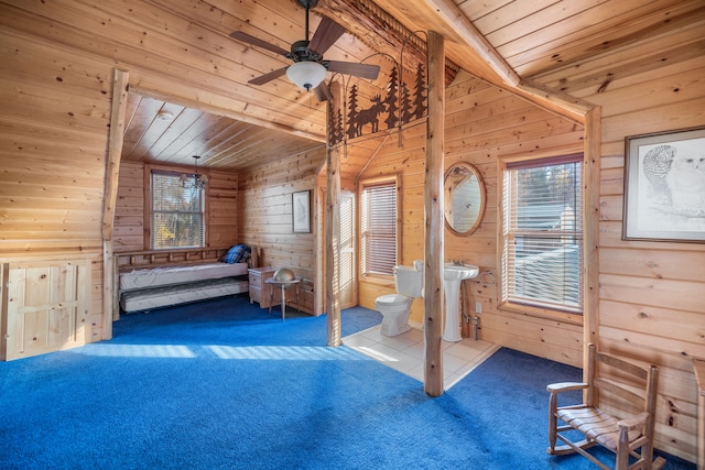 unfurnished bedroom featuring ceiling fan, wooden ceiling, wood walls, vaulted ceiling, and carpet