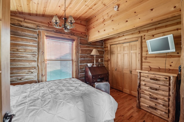 bedroom featuring wooden ceiling, a chandelier, light hardwood / wood-style floors, a closet, and lofted ceiling