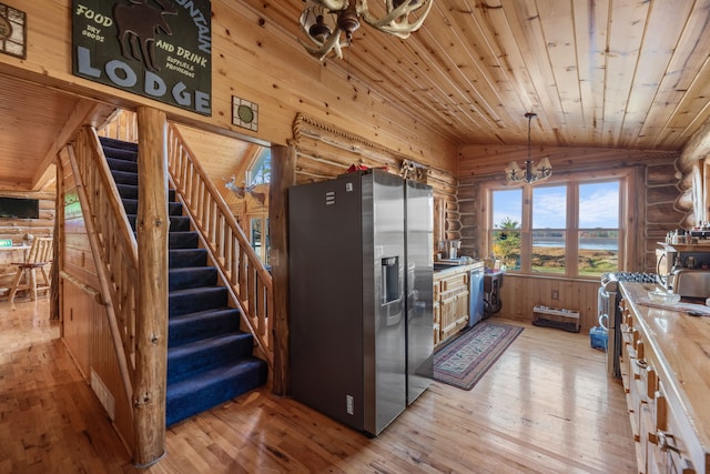 kitchen featuring appliances with stainless steel finishes, light wood-type flooring, an inviting chandelier, and lofted ceiling