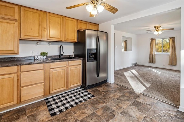 kitchen featuring ceiling fan, sink, light brown cabinets, dark colored carpet, and stainless steel fridge