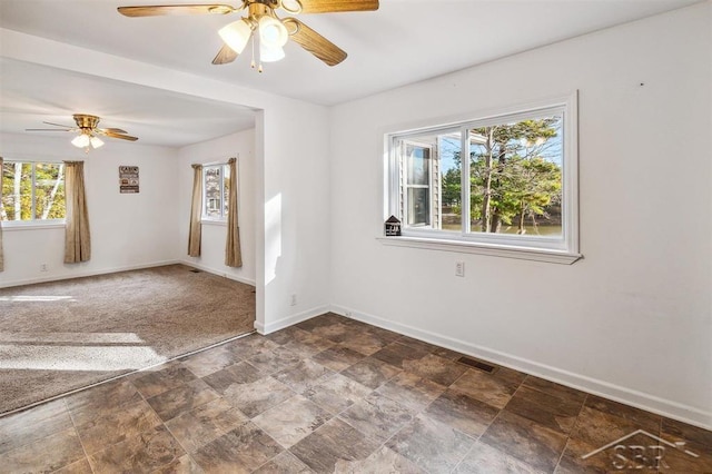 empty room with carpet, a wealth of natural light, and ceiling fan