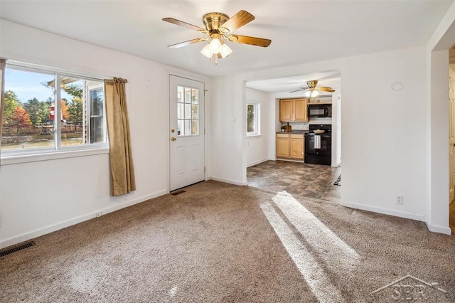 unfurnished living room featuring ceiling fan and carpet floors