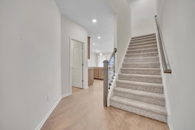 stairway featuring hardwood / wood-style floors and sink