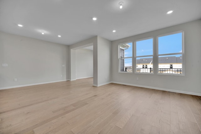 empty room featuring baseboards, light wood finished floors, and recessed lighting