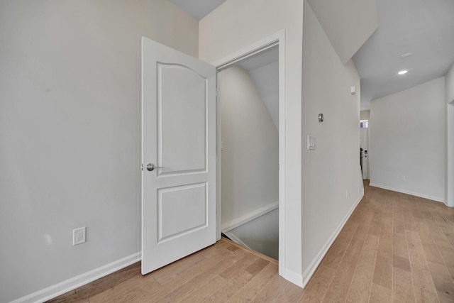 hallway featuring baseboards, recessed lighting, and light wood-style floors