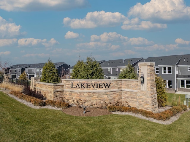community / neighborhood sign featuring a yard, a residential view, and fence