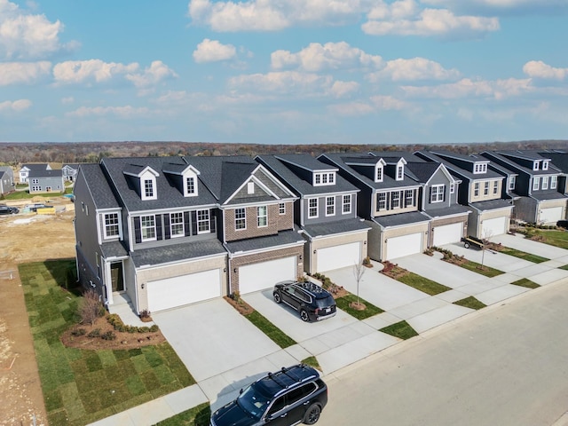 view of front facade with an attached garage, driveway, a residential view, and roof with shingles