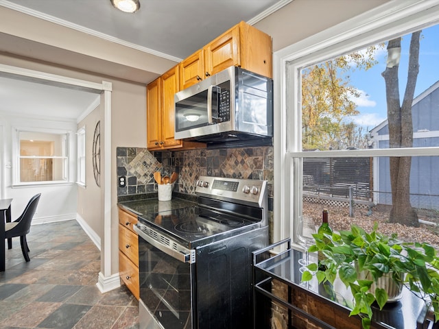 kitchen featuring decorative backsplash, ornamental molding, and appliances with stainless steel finishes