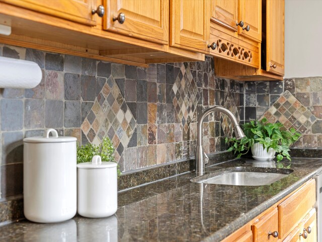 23096 Hawthorne St, Farmington, MI 48336 - kitchen with a sink, backsplash, dark stone counters, and brown cabinets