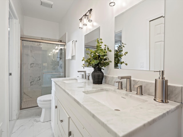 bathroom featuring vanity, a shower with shower door, and toilet