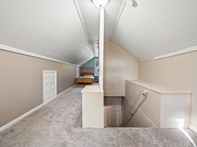 bonus room with light carpet, vaulted ceiling, and wooden walls