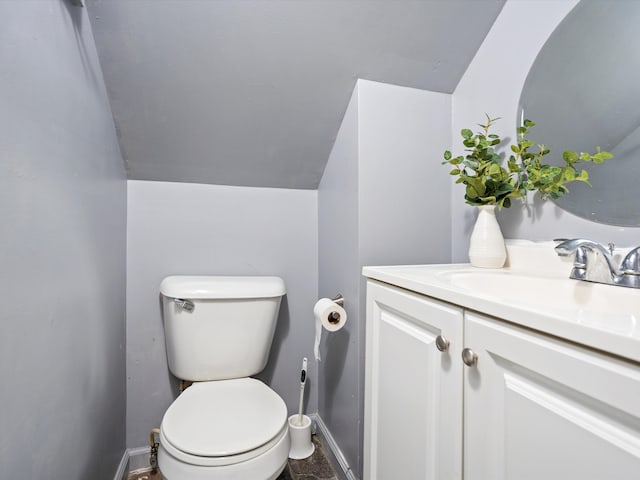 bathroom featuring vanity, toilet, and lofted ceiling