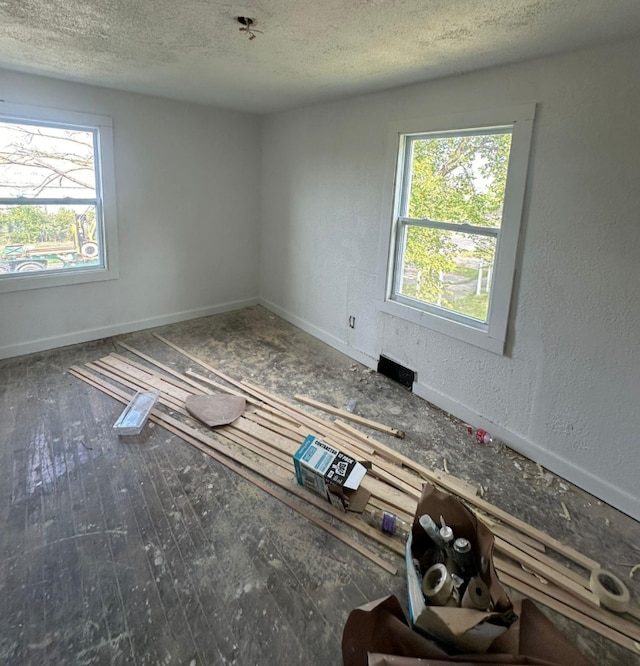 spare room with a textured ceiling and dark hardwood / wood-style flooring