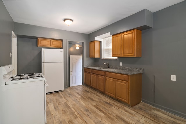 kitchen featuring light wood-type flooring, white appliances, and sink