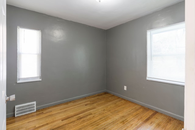 spare room featuring a healthy amount of sunlight and light hardwood / wood-style flooring