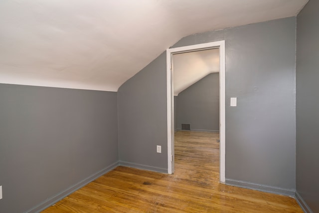 additional living space featuring light hardwood / wood-style floors and lofted ceiling