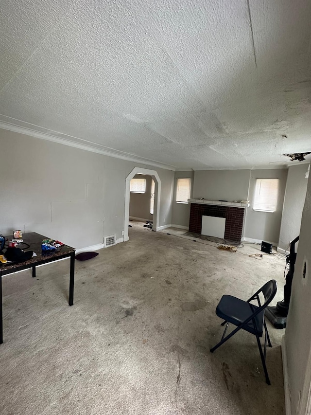 interior space with carpet, a brick fireplace, and a textured ceiling